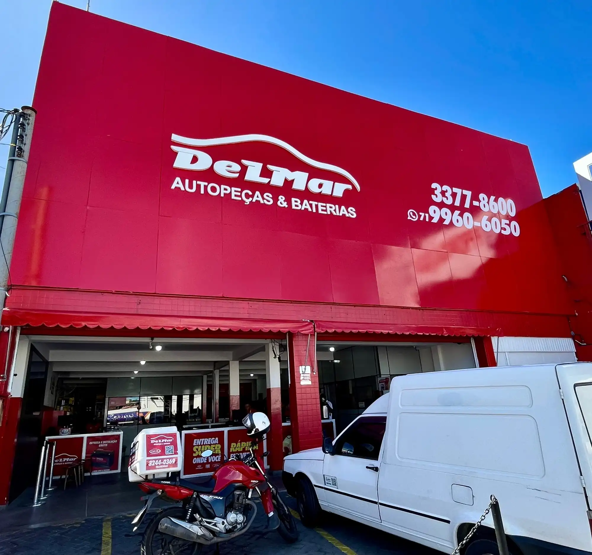 Loja DELMAR com moto e van de entrega em frente à fachada