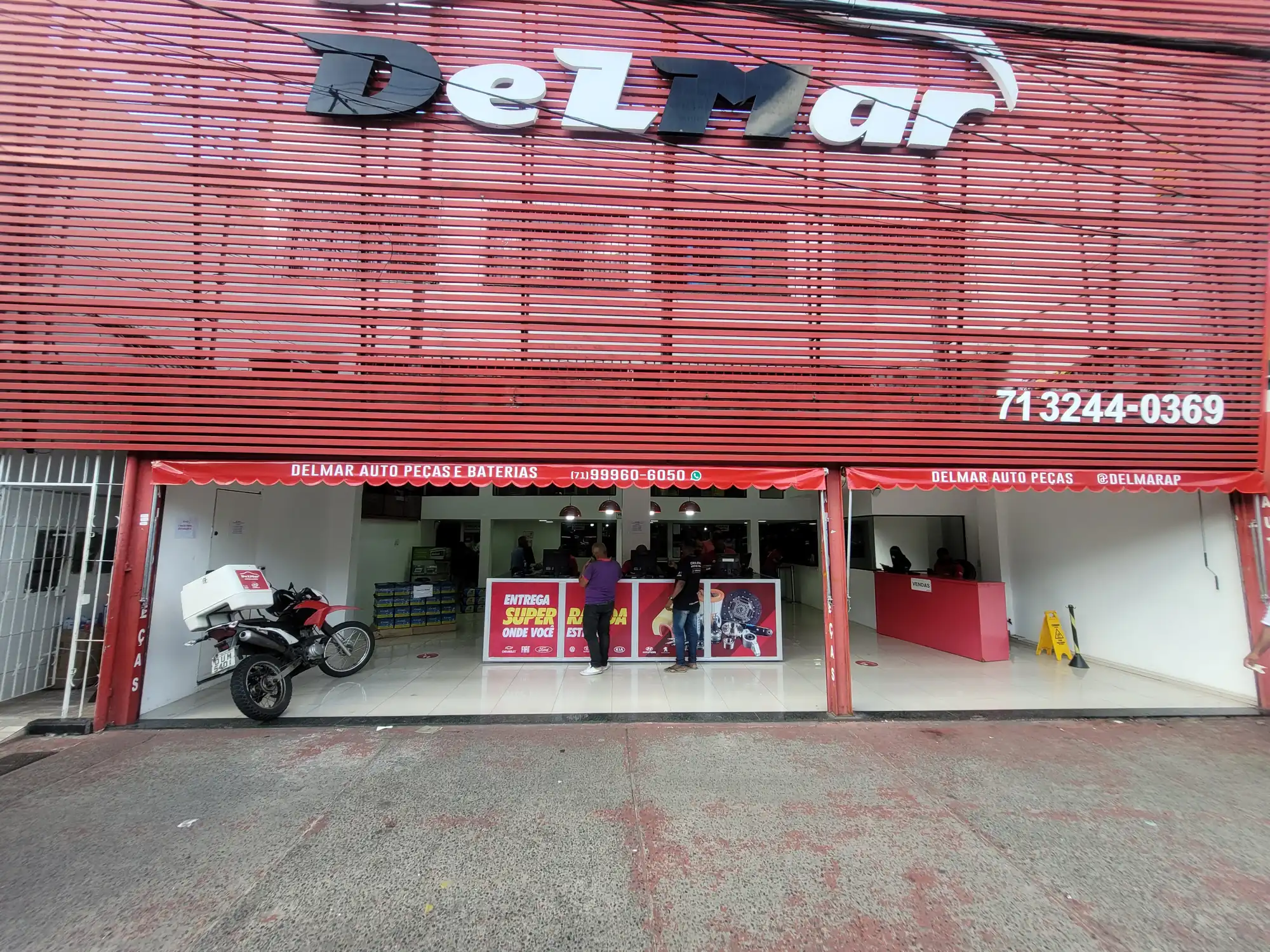 Balcão de atendimento da loja DELMAR com equipe e clientes